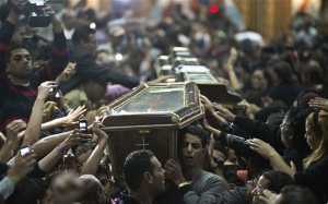Egpytian Copts carry four coffins down the aisle of the Virgin Mary Coptic Christian church. (Photo: AFP/GETTY)