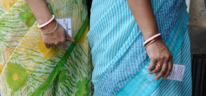 Women holding voter registration cards.  (Photo cred: Goutam Roy via Flickr)