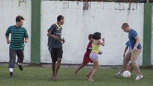 Student volunteers Dane Van Ryckeghem (far right) and Jordan O’Donnell (far left) play soccer with Brazilian children on the outskirts of Rio de Janeiro. (IMB) photo by Lina White