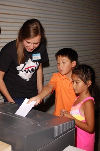 Nikki (summer intern) helping visiting students from a local Christian school summer camp  as they volunteer at the Advancing Native Missions office. (Image, caption courtesy ANM)