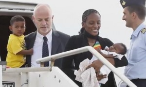 Meriam Ibrahim gets off the plane in Italy with her two children, escorted by an Italian official. 