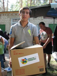 A Schools Without Walls student distributes aid to refugees from eastern Ukraine.  (Photo cred: Russian Ministries)