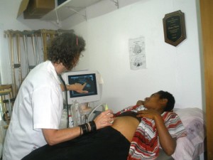 Missionary Lori Smith operates ultrasound machine on a new mom in Papua New Guinea.  (Photo, caption courtesy LMW)