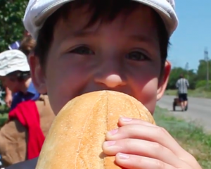A child bites into bread that Charlotte's $10 provided.  (Photo courtesy SGA)