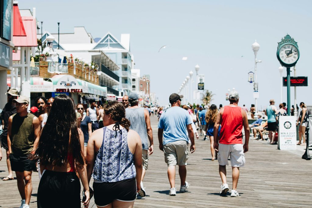 People walk down a boardwalk in summertime